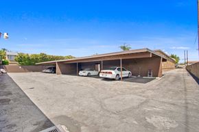 Downey apartment for rent - a parking lot with two cars in front of a building