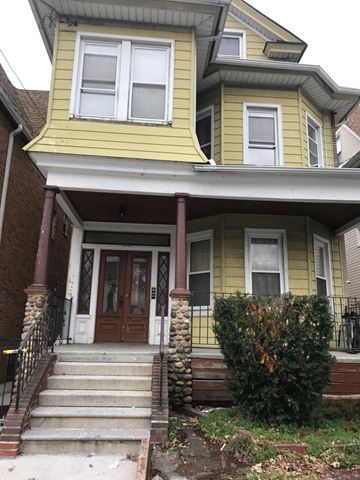 Elmhurst apartment for rent - a yellow house with steps in front of it