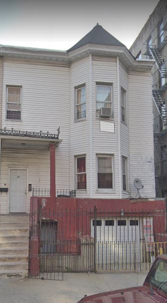 Bronx apartment for rent - a white house with a red fence in front of it