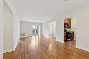Allentown apartment for rent - A spacious living room with wooden floors and white walls.