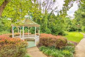 Frederick apartment for rent - gazebo at Creekside at Taskers Chance in Frederick, MD with bushes, shrubs and grass surrounding gazebo and walkway