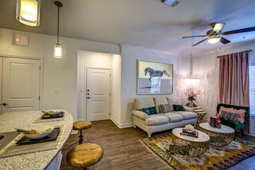 Denison apartment for rent - A living room with a couch, a chair, and a painting on the wall.