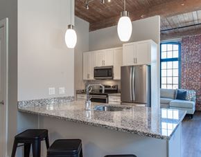 Lowell apartment for rent - a kitchen with a granite counter top and an island with stools