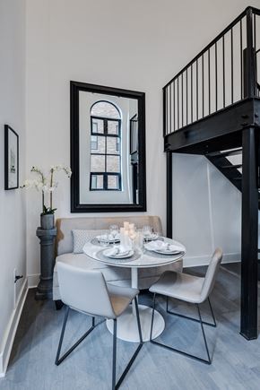 New York apartment for rent - a dining room with a table and chairs and a staircase