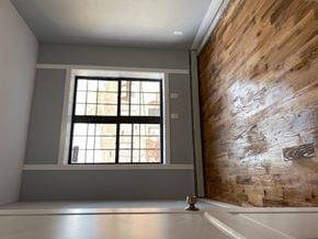 Brooklyn apartment for rent - an empty room with a window and a wooden wall