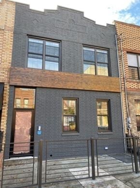 Brooklyn apartment for rent - a black brick building with windows and a fence