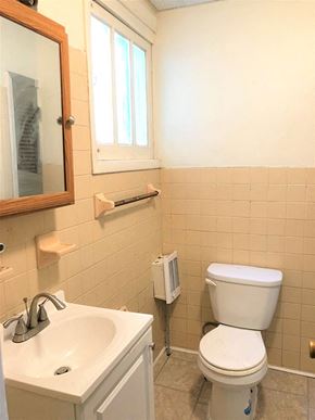 Philadelphia apartment for rent - A white toilet in a bathroom with a sink and mirror.