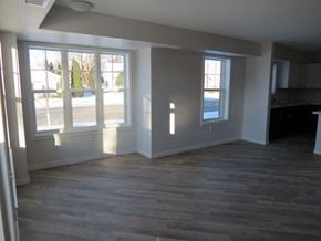 Cambridge apartment for rent - an empty living room with a wooden floor and large windows