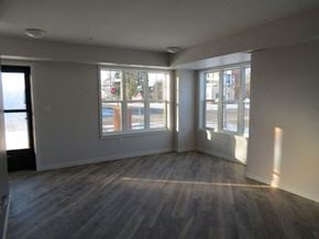 Cambridge apartment for rent - an empty living room with wood floors and large windows
