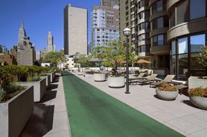 New York apartment for rent - a view of a sidewalk with benches and buildings in the background
