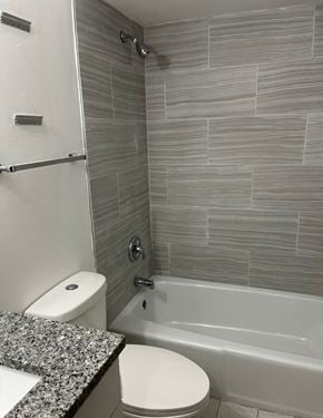 Oak Forest apartment for rent - A white toilet sits next to a bathtub in a bathroom.