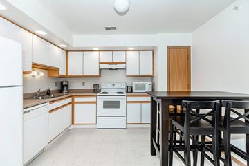 Dekalb apartment for rent - A kitchen with white appliances and wooden cabinets.
