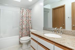 Dekalb apartment for rent - A white toilet with a floral shower curtain in a bathroom.