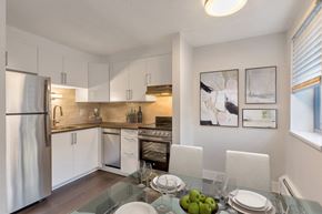 Denver apartment for rent - a kitchen and dining room with white cabinets and stainless steel appliances