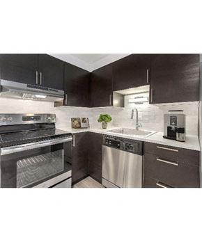 Denver apartment for rent - a kitchen with stainless steel appliances and black and white cabinets