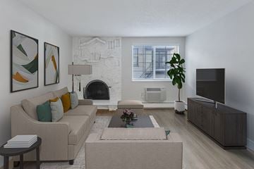 Denver apartment for rent - A living room with a beige couch, a coffee table, and a fireplace.