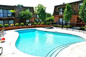 Kansas City apartment for rent - A swimming pool in a residential area surrounded by a black fence.
