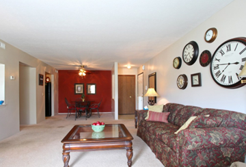 Brook Park apartment for rent - a living room with a couch and a coffee table and clocks on the wall