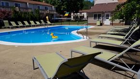Stow apartment for rent - a swimming pool with lounge chairs and chairs around it