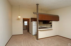 Stow apartment for rent - an empty living room with a kitchen and a refrigerator
