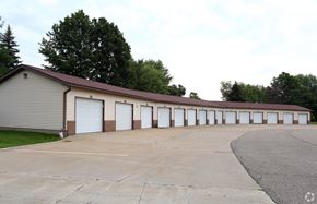 Stow apartment for rent - the outside of a building with white garage doors and a parking lot