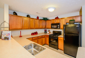 Kent apartment for rent - a kitchen with black appliances and wooden cabinets