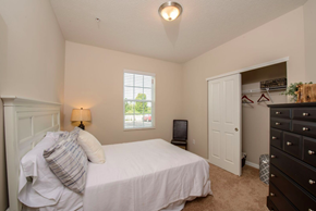 Gahanna apartment for rent - A bedroom with a bed, dresser, and window.