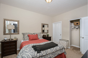 Westerville apartment for rent - A bedroom with a bed, nightstand, and two mirrors.