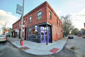 Kansa City apartment for rent - A red brick building with a purple door and a sign that says West Plaza.