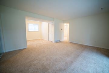 Kansas City apartment for rent - a living room with carpet and a door to a bedroom
