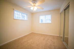 Kansas City apartment for rent - a bedroom with a ceiling fan and a mirrored closet