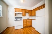 Kansas City apartment for rent - a kitchen with white appliances and wooden cabinets
