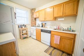 Kansas City apartment for rent - a kitchen with white appliances and wooden cabinets
