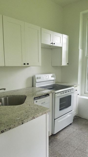 Philadelphia apartment for rent - an empty kitchen with white appliances and white cabinets
