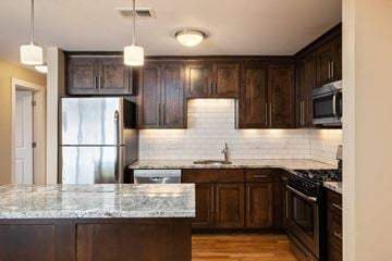 Kansas City apartment for rent - a kitchen with wooden cabinets and marble counter tops