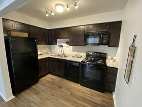 Beech Grove apartment for rent - A kitchen with black appliances and brown cabinets.
