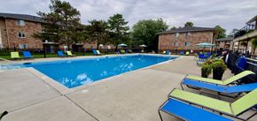 Beech Grove apartment for rent - A large swimming pool surrounded by lounge chairs and trees.