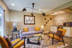 Oceanside apartment for rent - A living room with a grey couch, yellow chairs, and a glass coffee table.