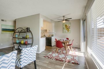 Oceanside apartment for rent - A dining room with a table set for two and a kitchen in the background.