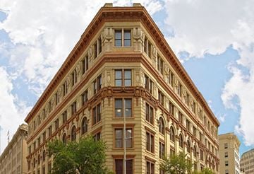 San Antonio apartment for rent - A large brown building with many windows and a triangular top.