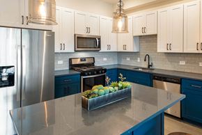 River Edge apartment for rent - a kitchen with blue and white cabinets and stainless steel appliances
