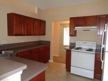 Jacksonville house for rent - A kitchen with a white stove and wooden cabinets.