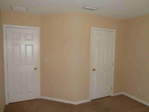 Jacksonville house for rent - A room with two white doors and beige walls.