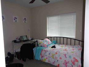 Jacksonville house for rent - A bedroom with a bed, desk, and fan.