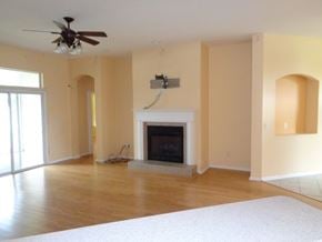 Orange Park house for rent - an empty living room with a fireplace and a ceiling fan