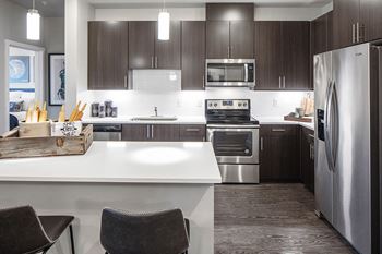 Baseline 158 - gourmet kitchen with island and pantries in select units