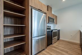 Seattle apartment for rent - a kitchen with a stainless steel refrigerator and a wooden cabinet