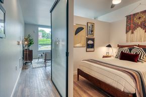 Seattle apartment for rent - a bedroom with a bed and a sliding glass door to a living room
