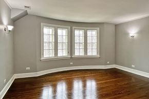 Oak Park apartment for rent - A room with wooden floors and three windows.