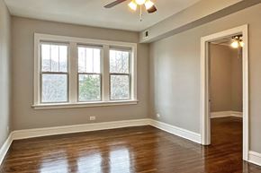 Oak Park apartment for rent - A room with a ceiling fan and a large window.